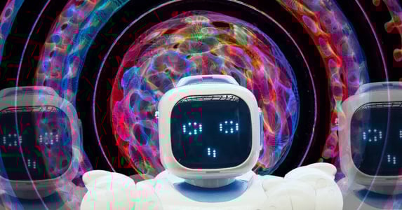 A white robot with a computerized face in front of a dizzying, colorful kaleidoscopic background.