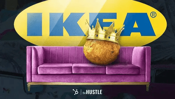 A meatball of exaggerated size sits on a purple sofa and wears a gold crown.