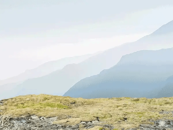 An animated GIF of Tom Cruise standing atop a moving motorcycle that flies off a rocky cliff; Cruise’s parachute deploys and carries him safely down, before he reemerges and winks.